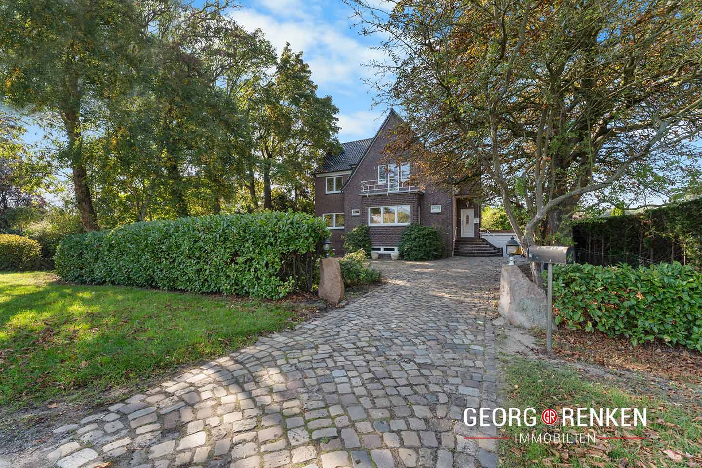 Blick Richtung Einfahrt, Hecke und Zweifamilienhaus